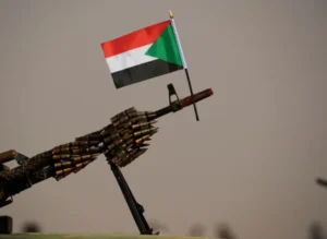 علم السودان معلق على رشاش آلي تابع لقوات الدعم السريع بالقرب من الخرطوم في 2019 (رويترز)