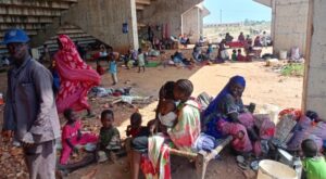 عائلات سودانية نازحة بسبب هجمات قوات الدعم السريع في كردفان تلجأ إلى ملعب كرة قدم (الفرنسية)